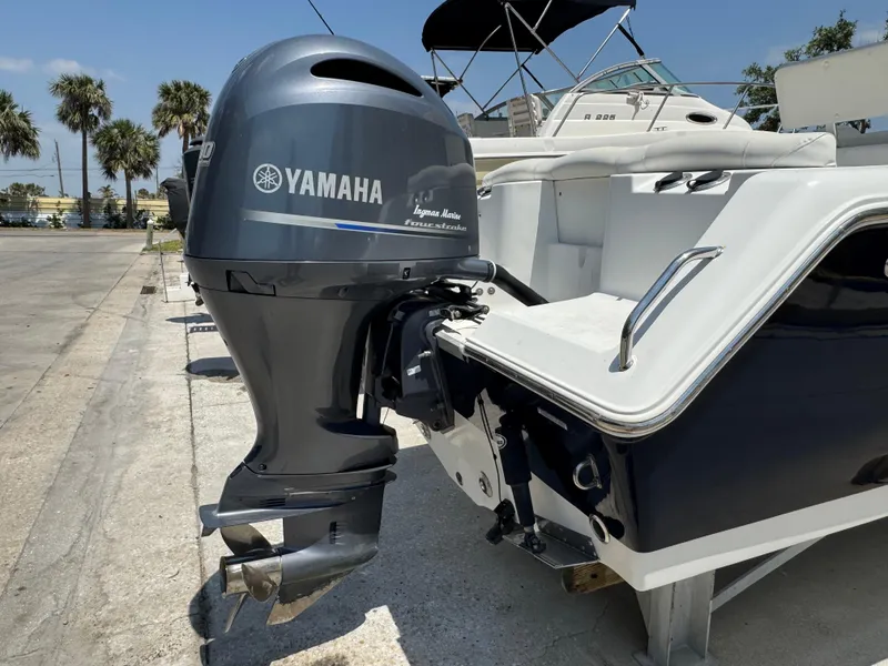 Slide: The Image of 2015 Sea Hunt Ultra 234 boat with Yamaha outboard motor, docked under clear skies. - 11