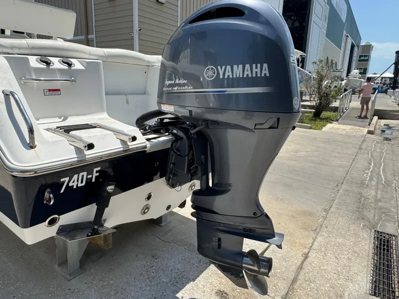 Slide: The Image of 2015 Sea Hunt Ultra 234 with Yamaha outboard motor, docked outdoors. - 12