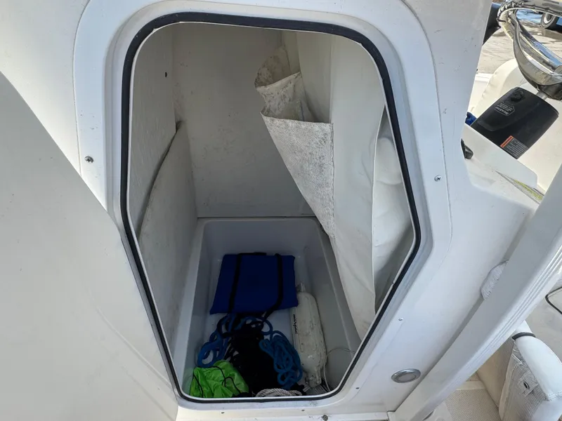 Slide: The Image of Storage compartment in 2015 Sea Hunt Ultra 234 boat, containing ropes and equipment. - 16