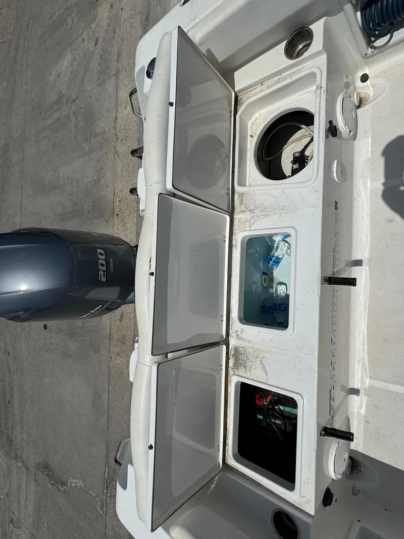 Slide: The Image of 2015 Sea Hunt Ultra 234 boat with open storage compartments and Yamaha 200 engine. - 17