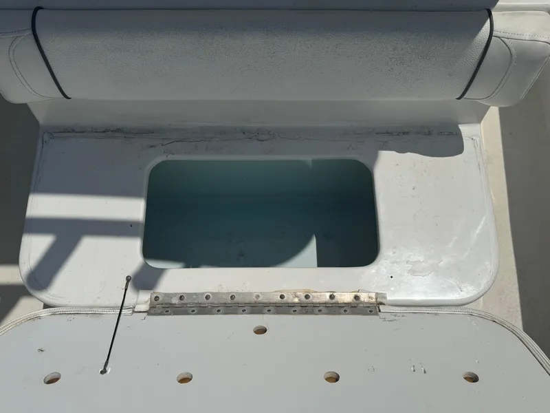 Slide: The Image of 2015 Sea Hunt Ultra 234 boat storage compartment with open lid. - 19