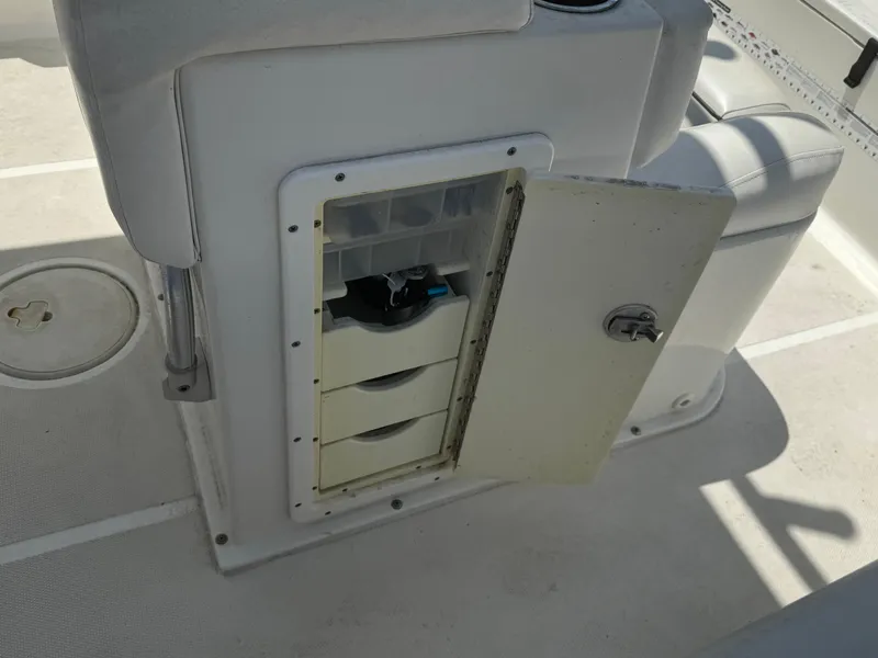 Slide: The Image of 2015 Sea Hunt Ultra 234 boat storage compartment with open door and organized shelves. - 20
