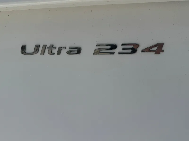 Slide: The Image of 2015 Sea Hunt Ultra 234 boat model emblem on white surface. - 22