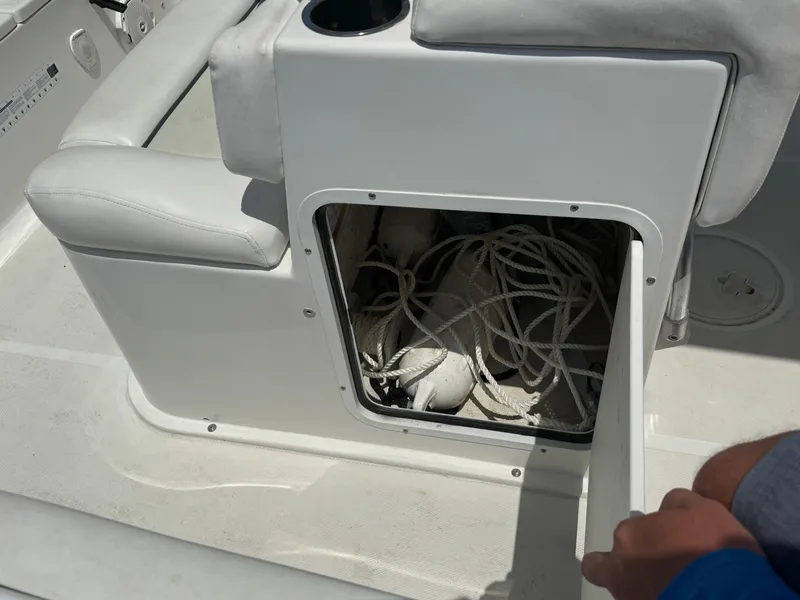 Slide: The Image of Storage compartment on a 2015 Sea Hunt Ultra 234 boat, containing ropes and equipment. - 24