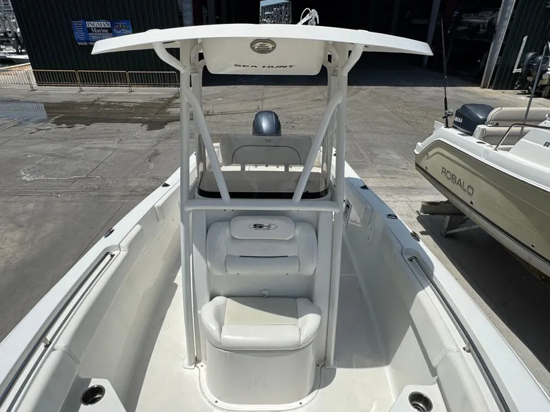 Slide: The Image of 2015 Sea Hunt Ultra 234 boat with T-top and seating, docked at marina. - 30