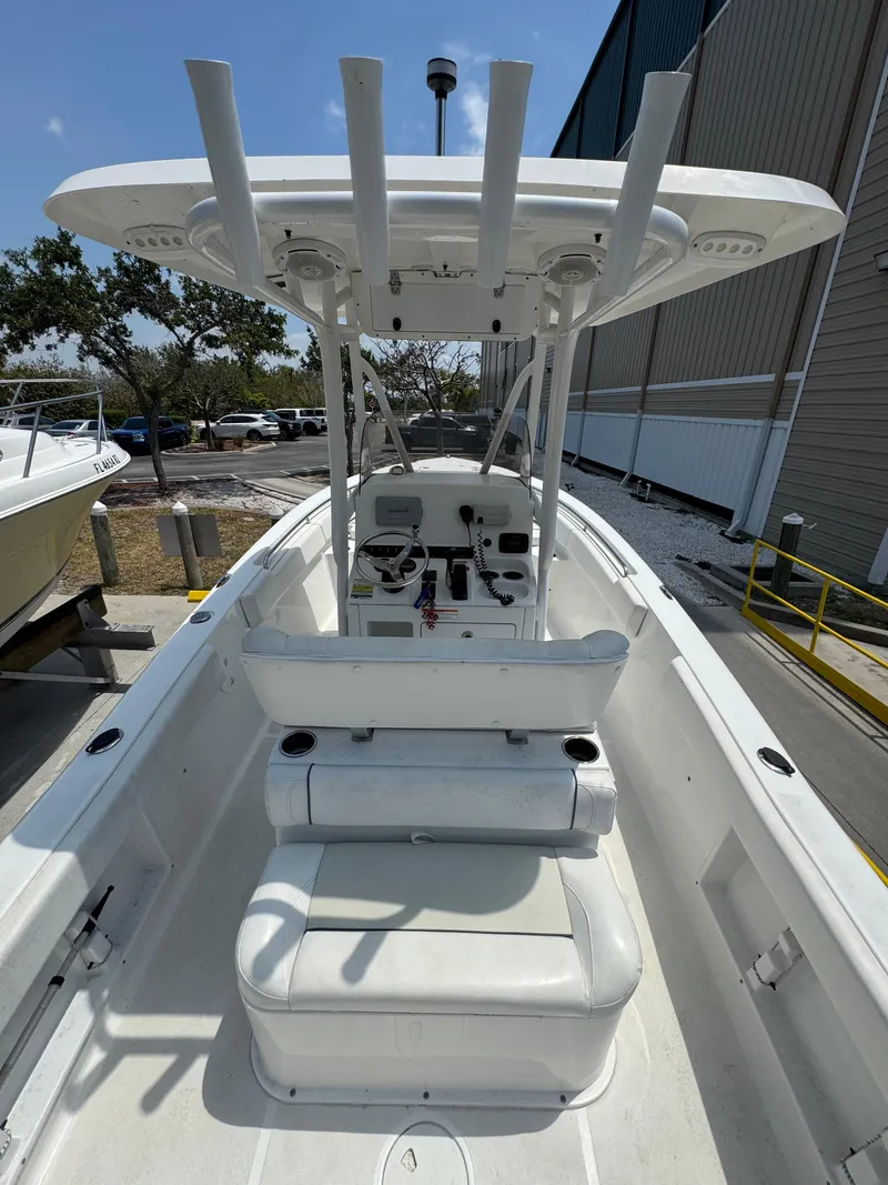 Slide: The Image of 2015 Sea Hunt Ultra 234 boat with T-top and seating, docked outdoors. - 32