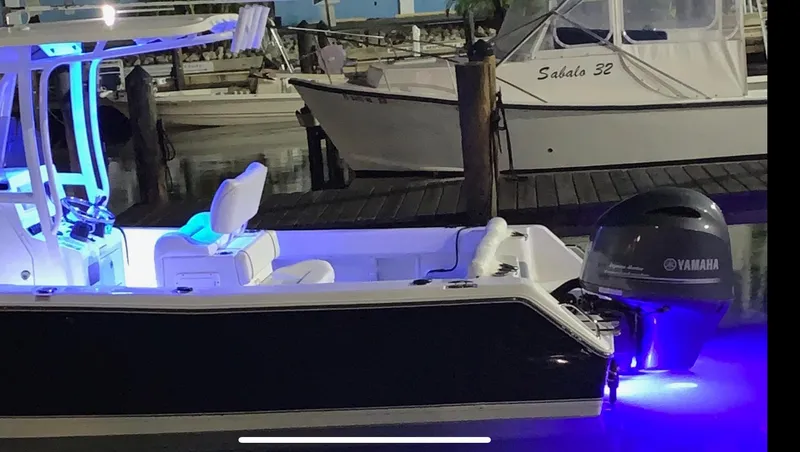 Slide: The Image of 2015 Sea Hunt Ultra 234 boat with Yamaha engine, illuminated at night in a marina. - 8