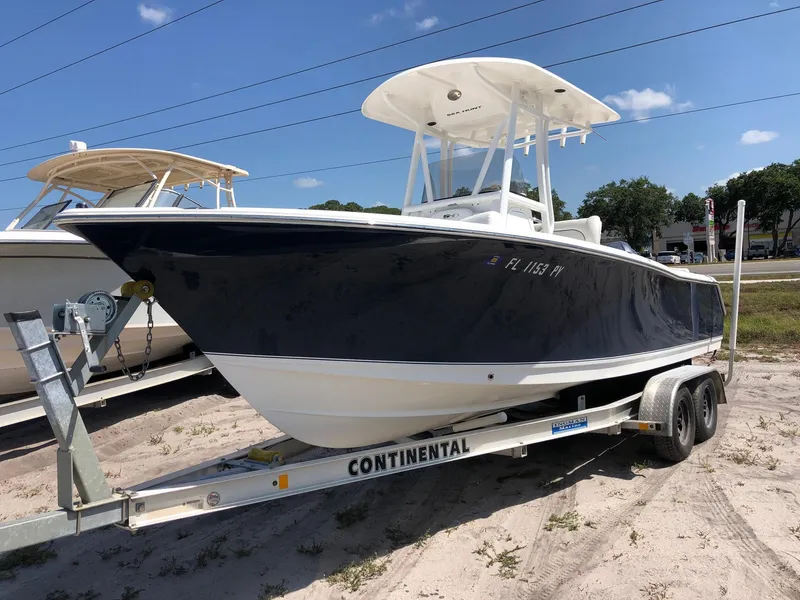 Slide: The Image of 2015 Sea Hunt Ultra 234 boat on trailer, parked outdoors under clear sky. - 9