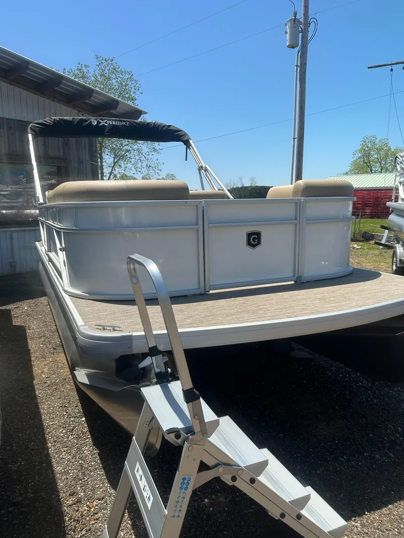 Slide: The Image of 2025 Godfrey Xperience 2086 CXP pontoon boat with ladder, docked outdoors. - 1
