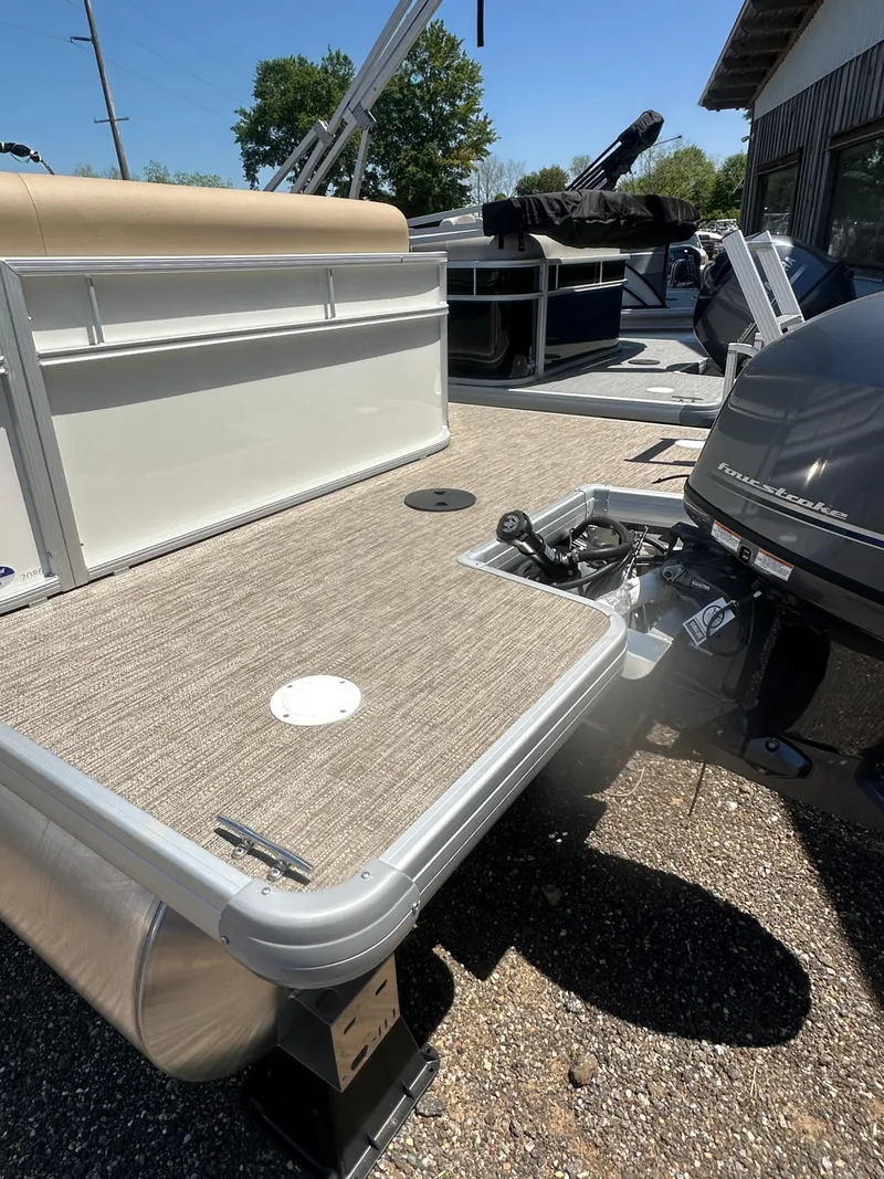 Slide: The Image of 2025 Godfrey Xperience 2086 CXP pontoon boat with outboard motor, docked under clear sky. - 7