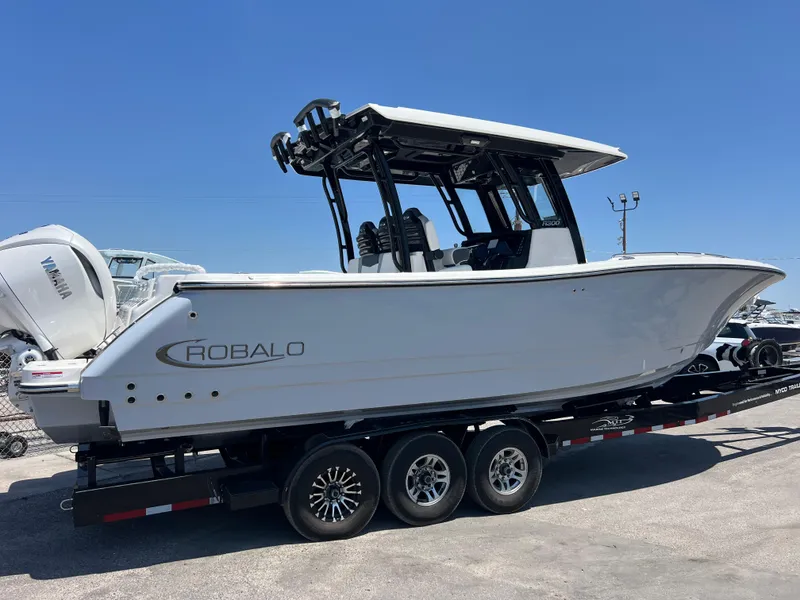 Slide: The Image of 2025 Robalo R300 Center Console boat with dual Yamaha engines on a trailer. - 4