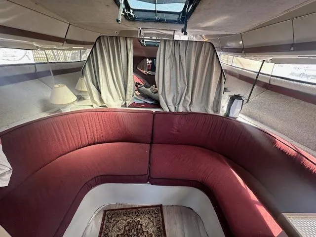 Slide: The Image of Interior of 1988 Carver 2767 Santego boat with red seating and curtains. - 22