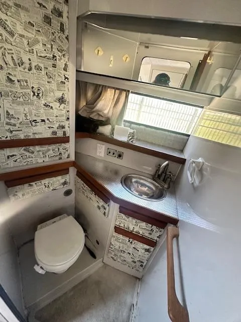 Slide: The Image of 1988 Carver 2767 Santego bathroom with comic-themed wallpaper, sink, and toilet. - 24