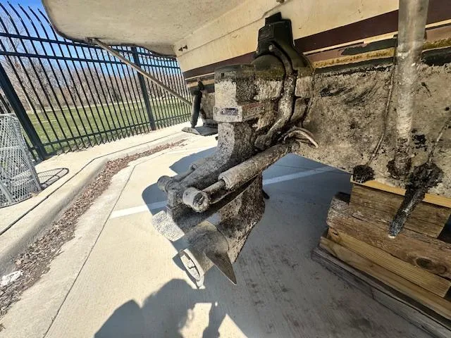 Slide: The Image of 1988 Carver 2767 Santego boat outdrive, weathered condition, parked on concrete near metal fence. - 5