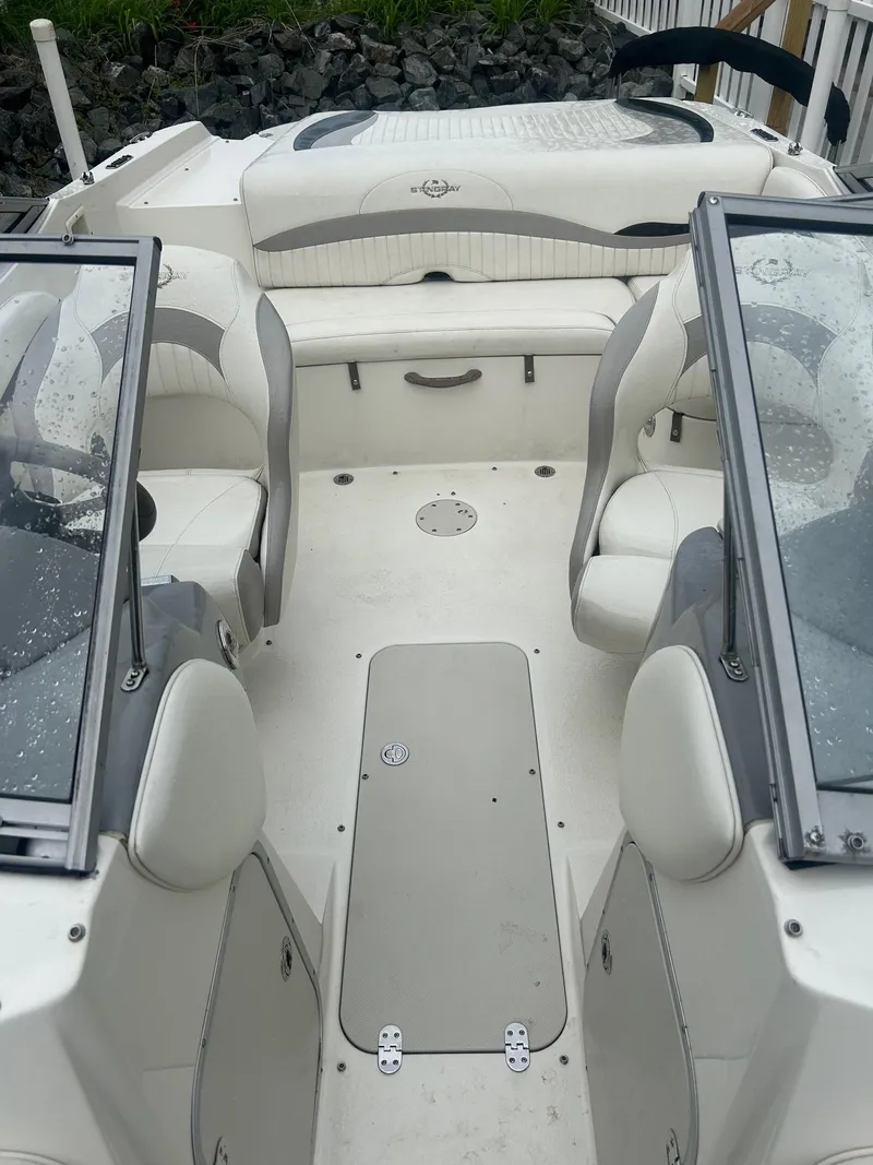 Slide: The Image of 2013 Stingray 208 LR boat interior with white seating and dual windshields. - 11