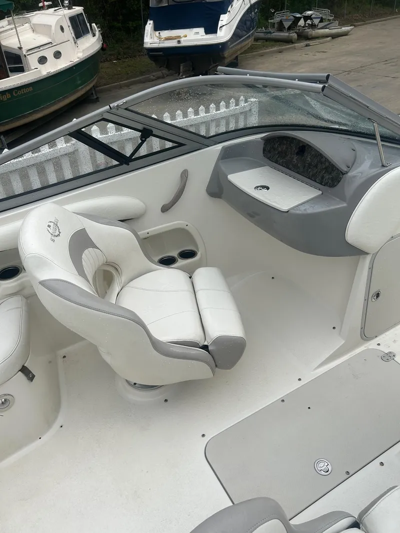 Slide: The Image of 2013 Stingray 208 LR boat interior with white seating and dashboard. - 13