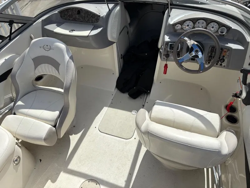 Slide: The Image of Interior of a 2013 Stingray 208 LR boat with white seating and dashboard. - 6