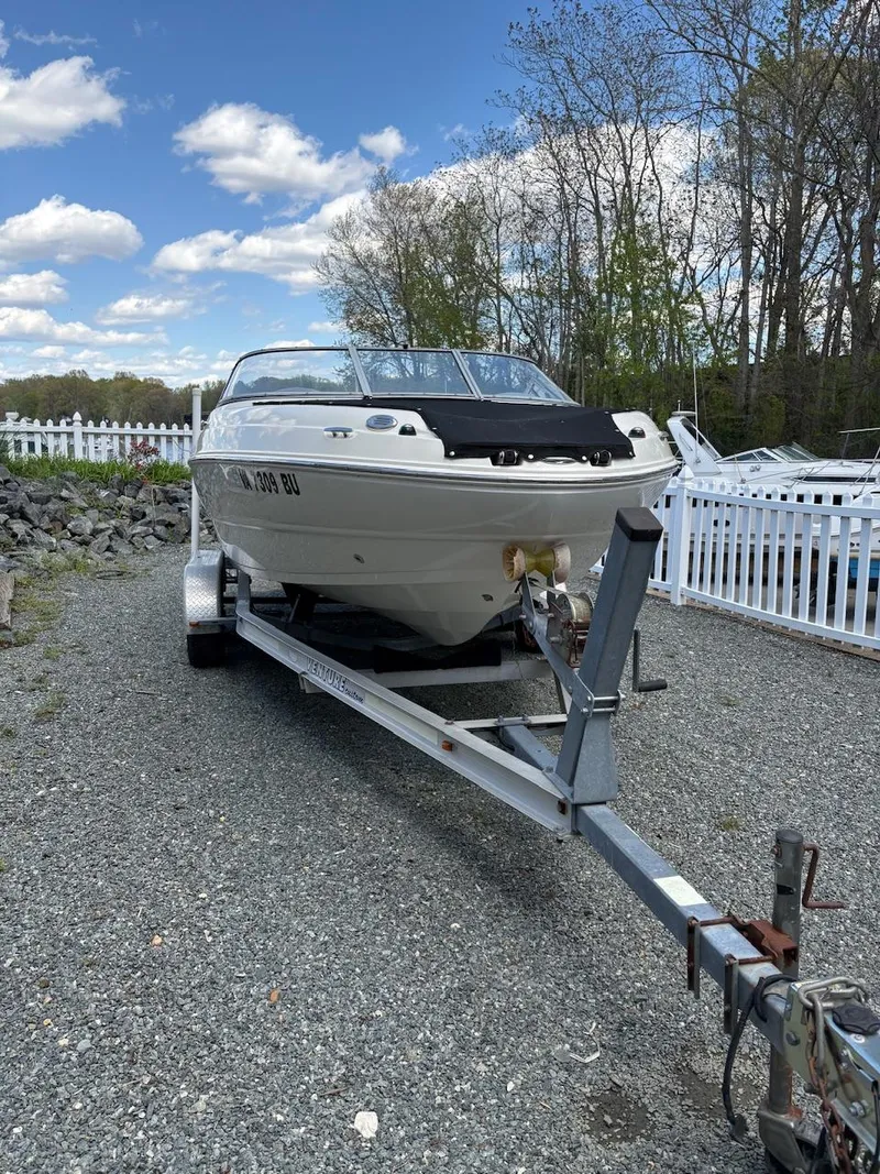 Slide: The Image of 2013 Stingray 208 LR boat on trailer, parked outdoors under a blue sky. - 8