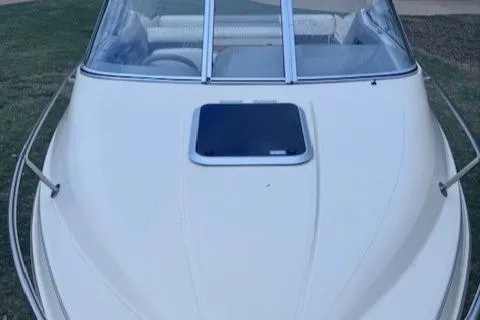 Slide: The Image of 1994 Maxum 2000 SC boat, white exterior, windshield, and hatch, parked on grass. - 2