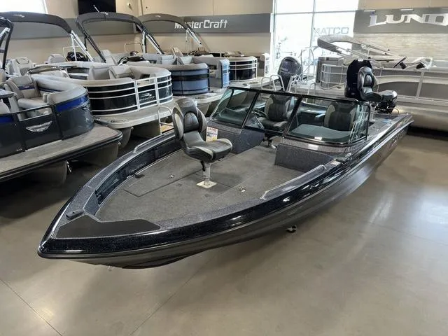 Slide: The Image of 2024 Lund 219 Pro-V GL Sport boat displayed in showroom, surrounded by other boats. - 11