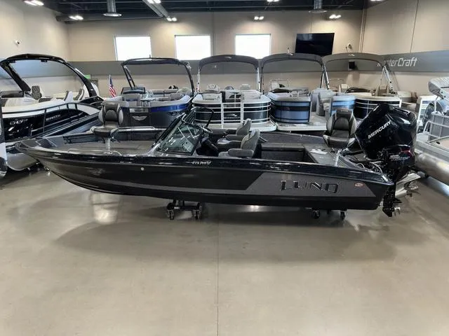 Slide: The Image of 2024 Lund 219 Pro-V GL Sport boat displayed in a showroom with other boats. - 3
