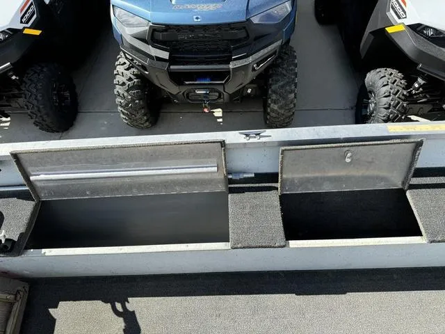 Slide: The Image of 1992 Tracker Super 17 Pro boat storage compartments with off-road vehicles in the background. - 12