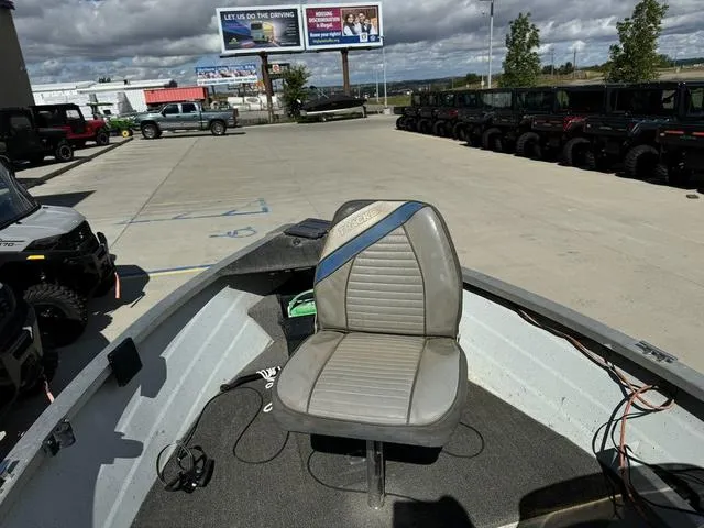 Slide: The Image of 1992 Tracker Super 17 Pro boat seat in a dealership lot under cloudy skies. - 14