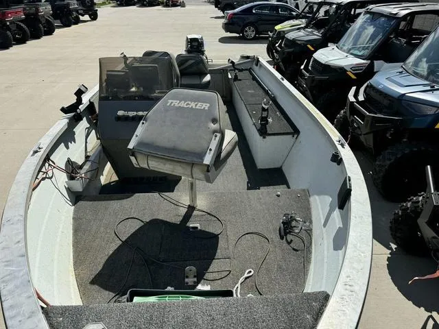 Slide: The Image of 1992 Tracker Super 17 Pro boat interior with seating and controls, parked among vehicles. - 6