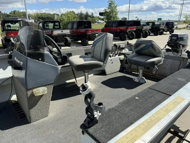 Slide: The Image of 1992 Tracker Super 17 Pro boat interior with seats and steering wheel, parked near vehicles. - 7