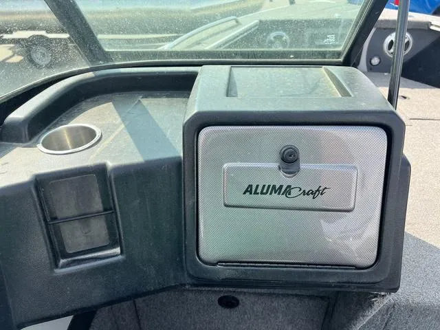 Slide: The Image of 2020 Alumacraft Trophy 185 boat dashboard with storage compartment and cup holder. - 15