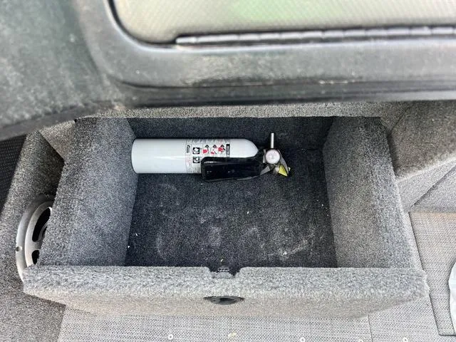 Slide: The Image of Storage compartment in 2020 Alumacraft Trophy 185 with fire extinguisher and keys. - 17