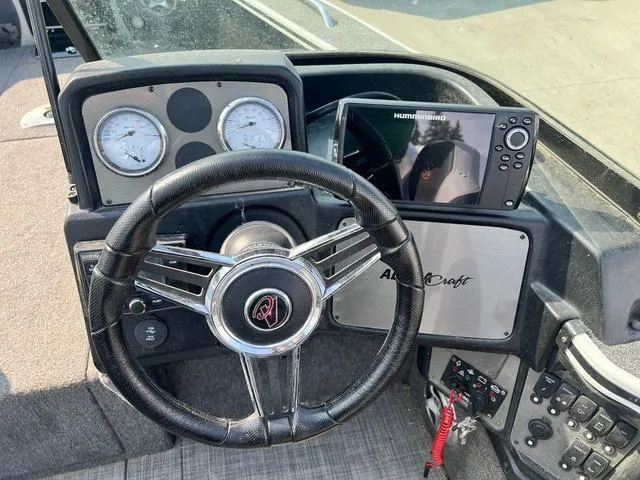 Slide: The Image of 2020 Alumacraft Trophy 185 dashboard with steering wheel, gauges, and Humminbird fish finder. - 8