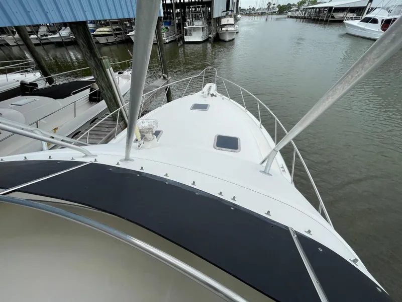 Slide: The Image of 1990 Tiara Yachts 4300 Convertible docked at marina, view from bow. - 10