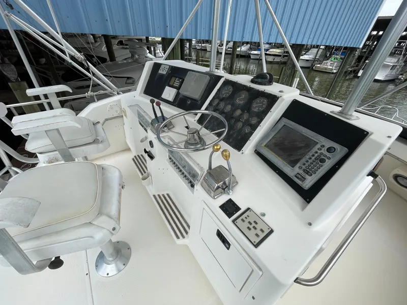 Slide: The Image of 1990 Tiara Yachts 4300 Convertible helm with steering wheel and navigation instruments. - 11