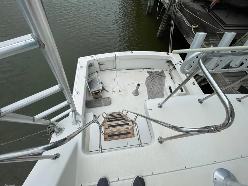 Slide: The Image of 1990 Tiara Yachts 4300 Convertible deck view with ladder and railing. - 12