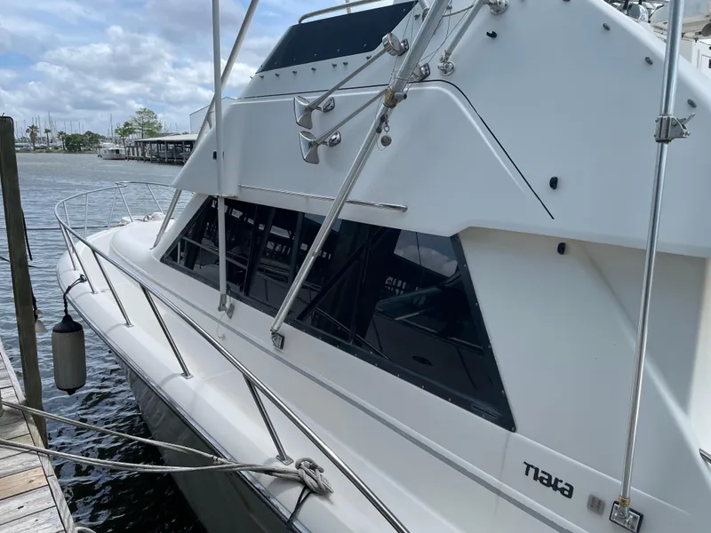 Slide: The Image of 1990 Tiara Yachts 4300 Convertible docked, showcasing sleek design and spacious windows. - 15