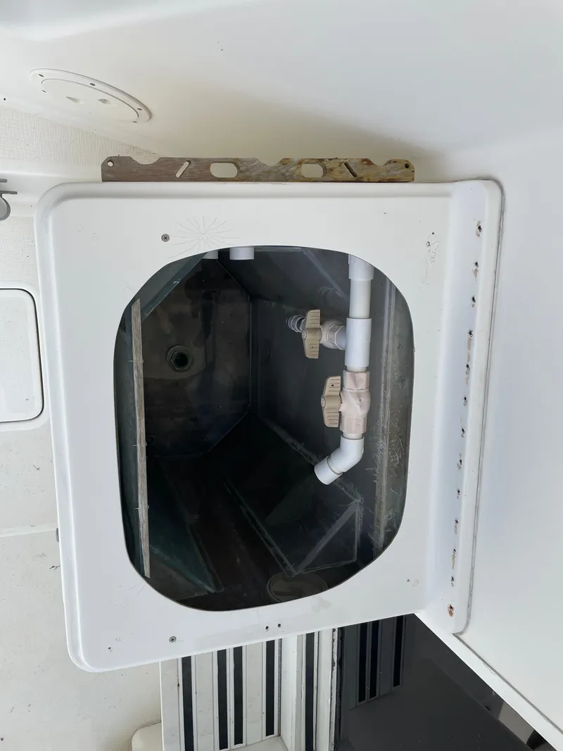 Slide: The Image of 1990 Tiara Yachts 4300 Convertible plumbing compartment with visible pipes and fittings. - 17