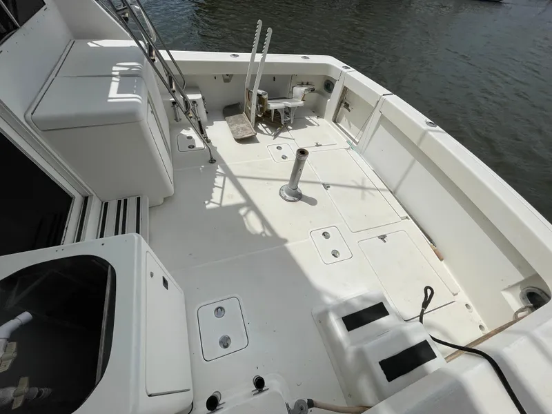 Slide: The Image of 1990 Tiara Yachts 4300 Convertible deck, featuring spacious layout and fishing equipment. - 19