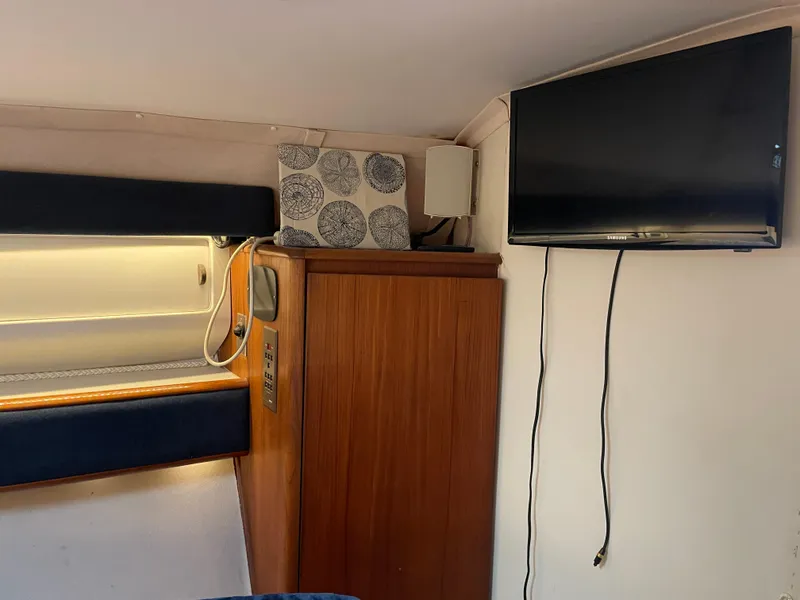 Slide: The Image of 1990 Tiara Yachts 4300 Convertible interior with TV and wooden cabinet. - 21