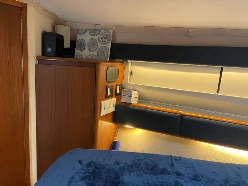 Slide: The Image of Interior cabin of 1990 Tiara Yachts 4300 Convertible with wood paneling and blue bedding. - 22