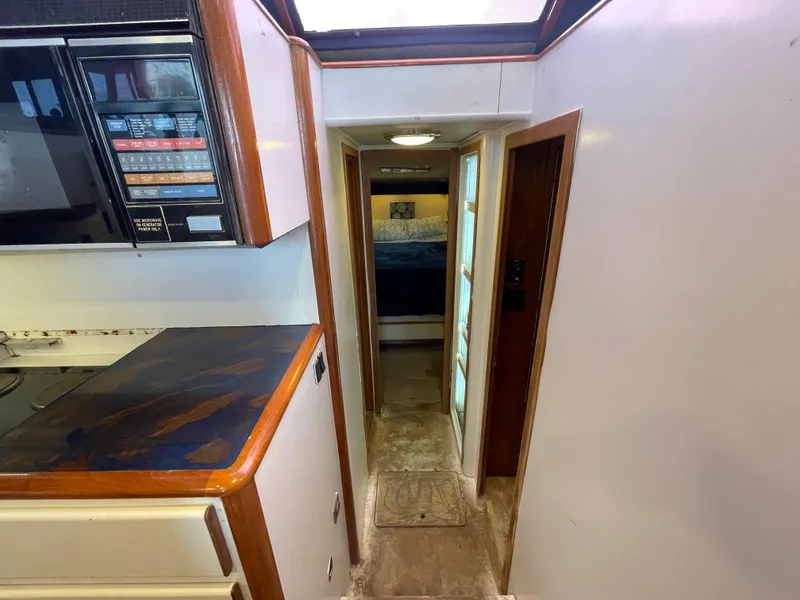 Slide: The Image of 1990 Tiara Yachts 4300 Convertible interior hallway with kitchen view. - 26