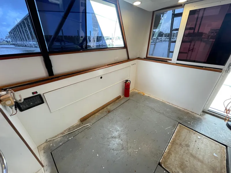 Slide: The Image of 1990 Tiara Yachts 4300 Convertible interior with windows, fire extinguisher, and spacious layout. - 27