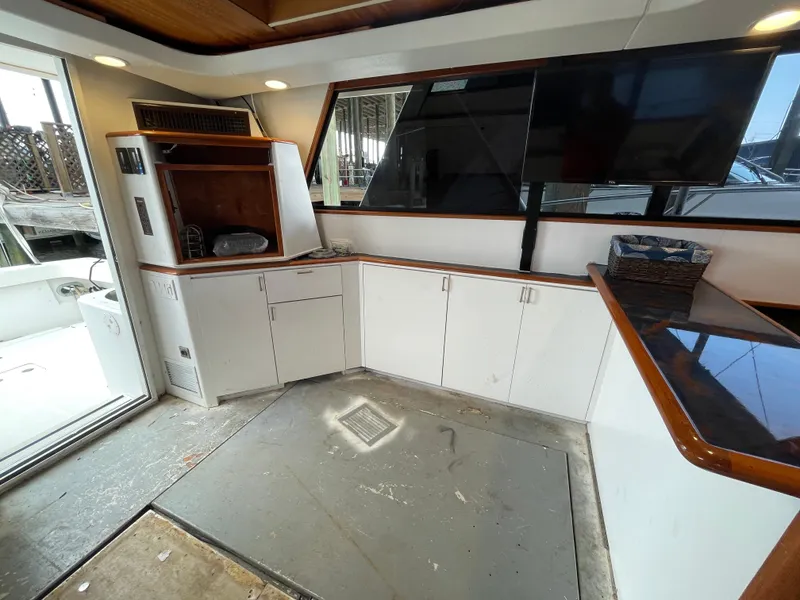 Slide: The Image of Interior of 1990 Tiara Yachts 4300 Convertible with white cabinetry and large windows. - 28