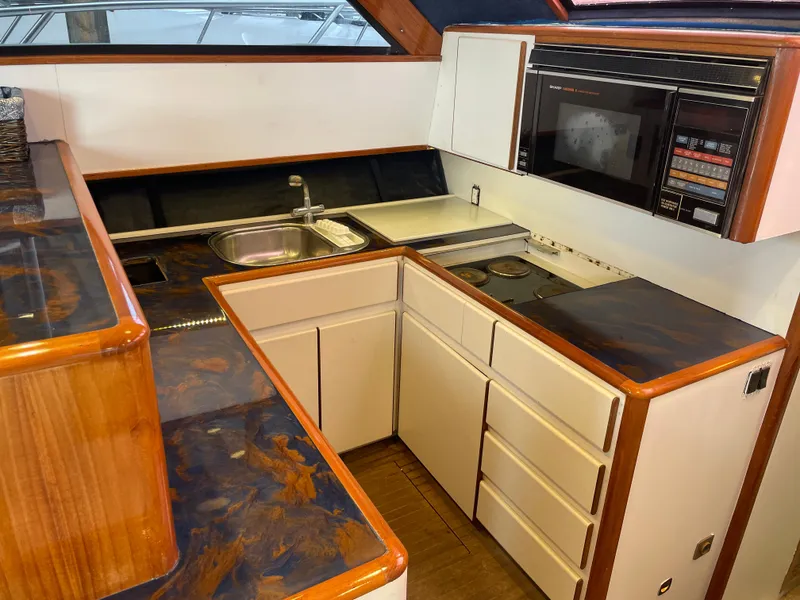 Slide: The Image of 1990 Tiara Yachts 4300 Convertible kitchen with wood accents and modern appliances. - 34