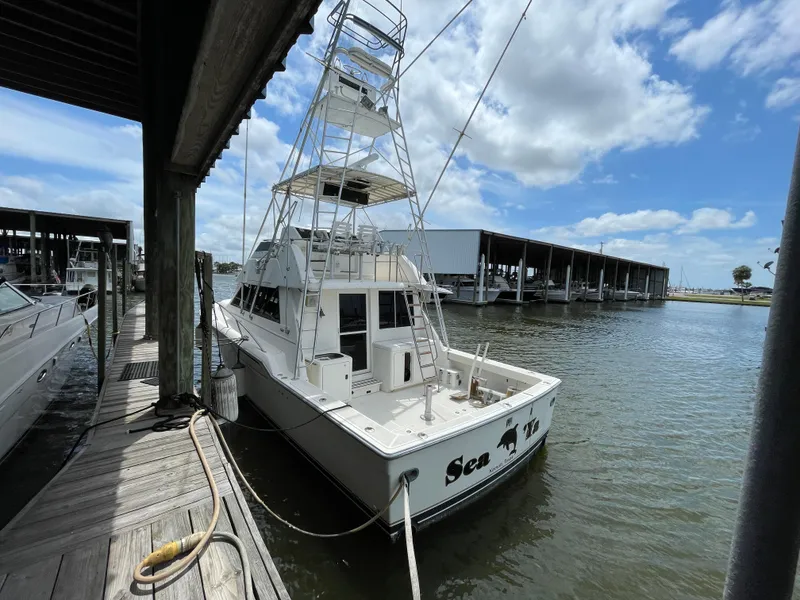 Slide: The Image of 1990 Tiara Yachts 4300 Convertible docked at marina under blue sky. - 5
