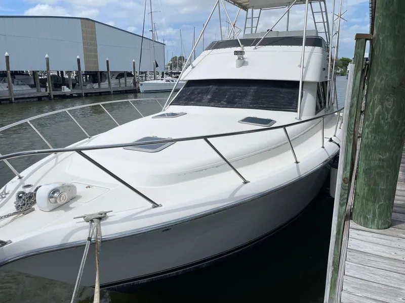Slide: The Image of 1990 Tiara Yachts 4300 Convertible docked at marina, side view. - 6