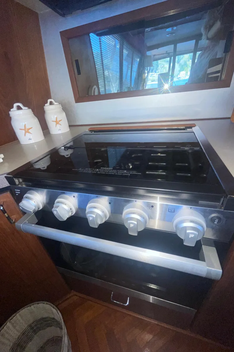 Slide: The Image of 1992 Bayliner 4588 Pilothouse kitchen with modern stove and decorative jars. - 11