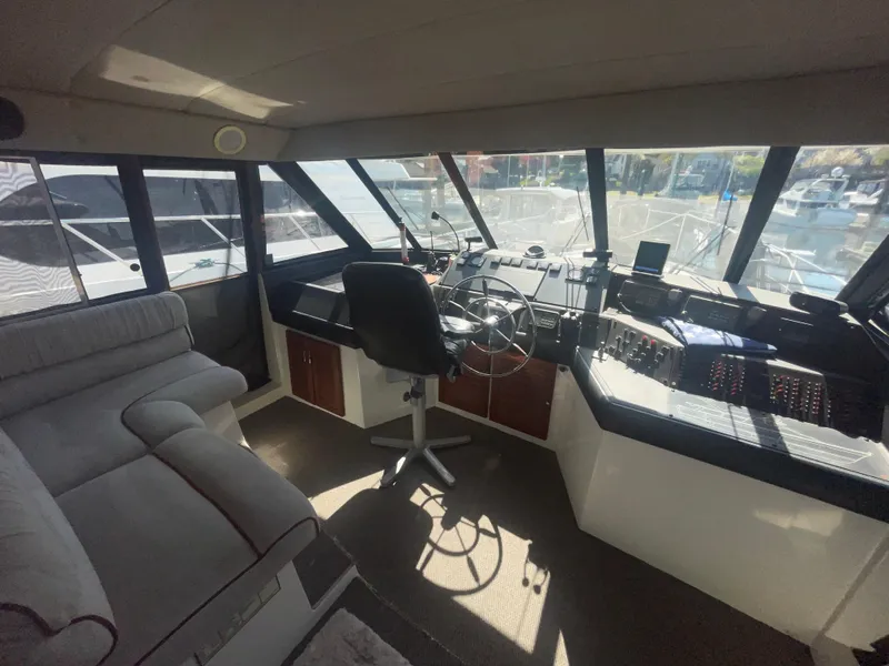 Slide: The Image of Pilothouse interior of 1992 Bayliner 4588, featuring steering wheel, seating, and panoramic windows. - 13