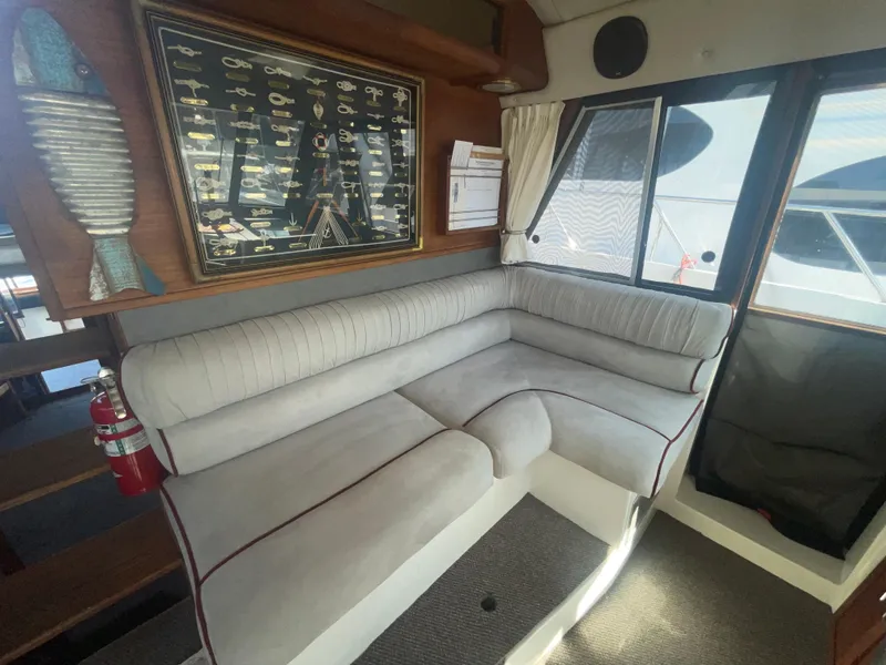 Slide: The Image of 1992 Bayliner 4588 Pilothouse interior with cushioned seating and nautical decor. - 14