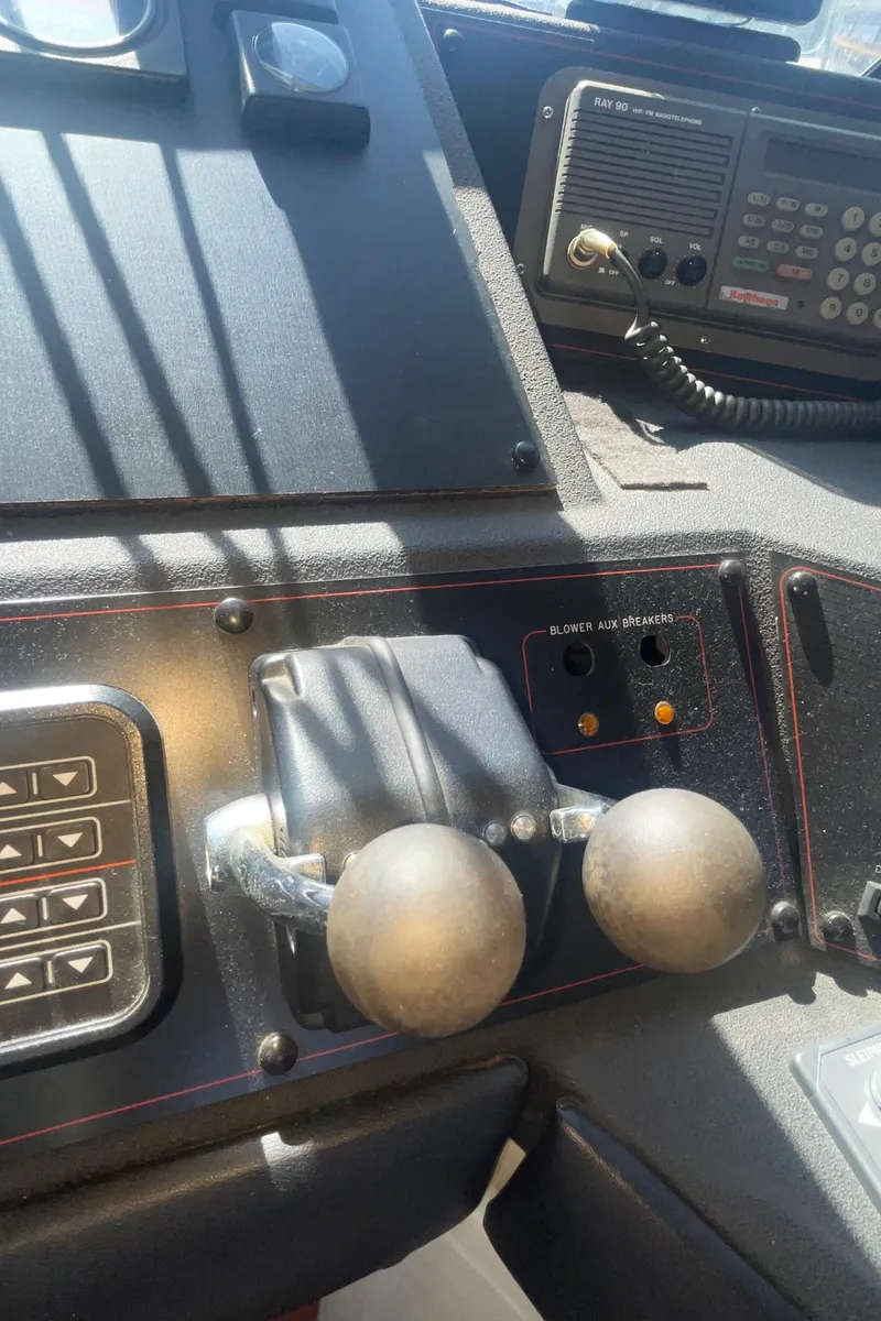 Slide: The Image of 1992 Bayliner 4588 Pilothouse control panel with dual throttle levers and radio equipment. - 16
